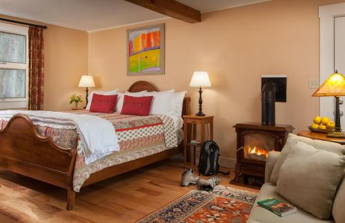a bedroom with a bed with red pillows and a fireplace at Sugar Hill Inn in Sugar Hill