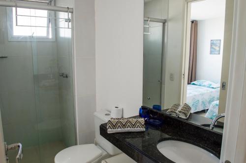 y baño con aseo, lavabo y ducha. en Apartamento Deluxe Ahead Ponta Negra, en Natal