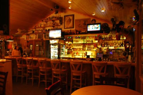 un bar avec beaucoup de tabourets de bar dans l'établissement Lava Mountain Lodge, à Dubois