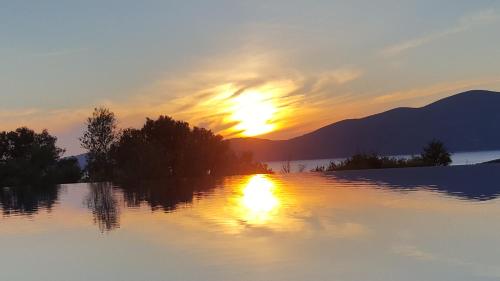 a sunset over a lake with the sun setting at Villa Del Mar in Vasiliki