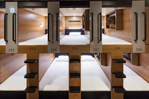 a room with four bunk beds in it at Y's CABIN Osaka Namba in Osaka