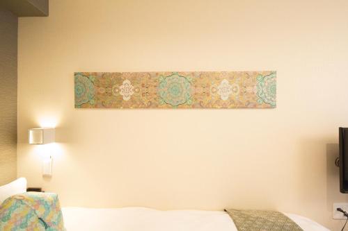 un dipinto appeso a un muro sopra un letto di Gion HANNA STAY a Kyoto