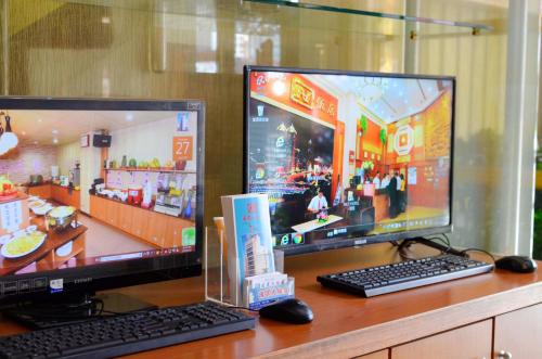 two computer monitors sitting on top of a desk at Nice Hotel in Kaohsiung
