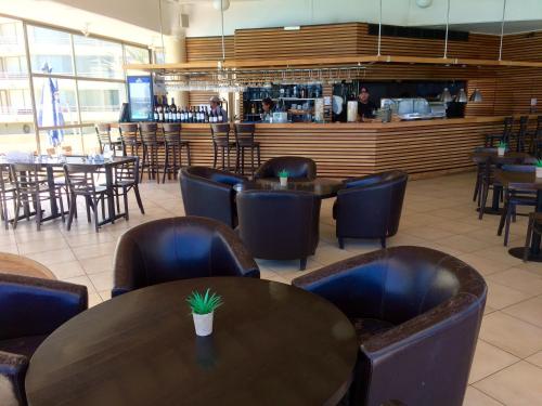 un restaurante con mesas y sillas y un bar en San Alfonso del Mar Resort, en Algarrobo