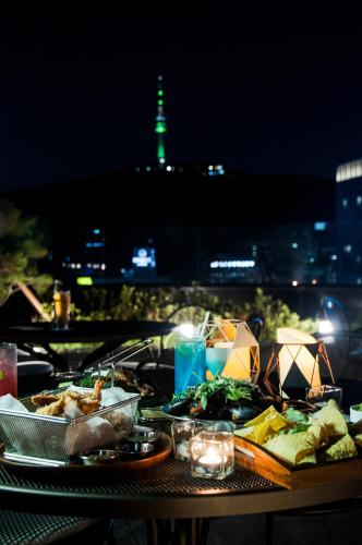 a table with food on it with a view of the city at G2 Hotel Myeongdong in Seoul