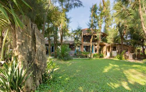 會安的住宿－安邦海洋之家別墅，庭院前有棕榈树的房子