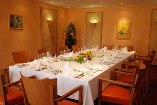 a long table with white tables and chairs in a room at ABACUS Tierpark Hotel in Berlin
