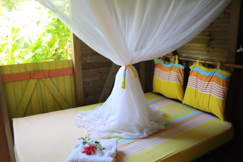 a room with a bed with a canopy and chairs at Gites "An-TIKAZ-La" in Trois-Rivières
