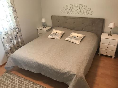 een slaapkamer met een bed met 2 kussens erop bij Ranua Lapland Apartment in Ranua