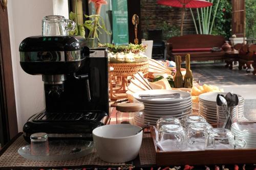 een koffiezetapparaat op een tafel met borden en kopjes bij Risasinee Spa & Resort in Nan