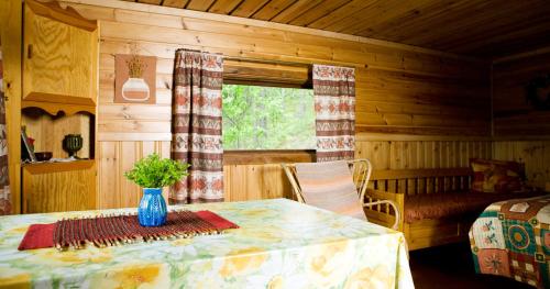 a wooden room with a table and a window at Tivoli Cottage in Talviainen