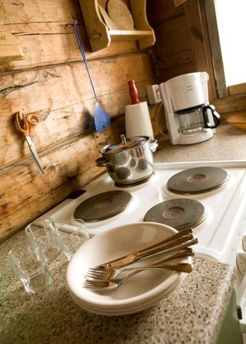 eine Herdplatte mit einem Teller und Gabeln darauf in der Unterkunft Tivoli Cottage in Talviainen