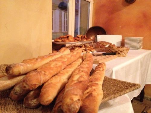 a table with a bunch of bread and pastries at Hôtel Du Théâtre Centre Historique - Parking Souterrain Public Gratuit in Metz
