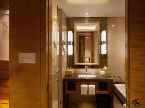 a bathroom with a sink and a mirror at Kunshan Jinling Hotel in Kunshan