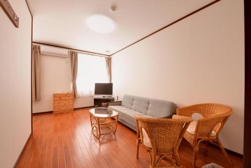 a living room with a couch and chairs and a table at Lodge B&W in Minami Uonuma