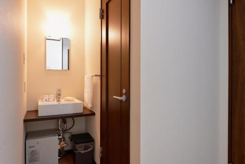 a bathroom with a sink and a mirror at Lodge B&W in Minami Uonuma