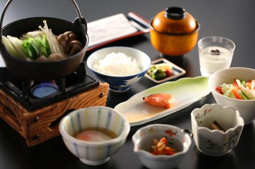 Nukumorino-yado Komanoyu في كيسو: طاولة مع أطباق من الطعام وقدر من الأرز