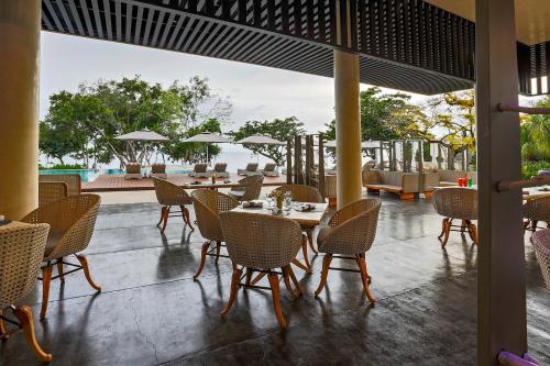 a restaurant with tables and chairs and a view of the ocean at Amorita Resort in Panglao Island