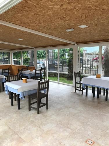 a dining room with tables and chairs and windows at Hotel Palacio de Garaña in Garaña