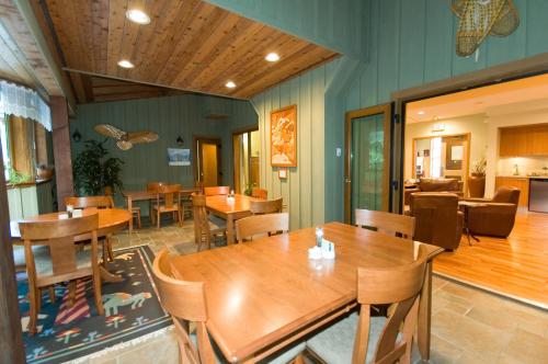comedor con mesas y sillas de madera en Whistler Alpine Chalet Retreat & Wellness, en Whistler