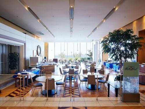 a restaurant with tables and chairs in a building at Hotel Seagull Tenpozan Osaka in Osaka