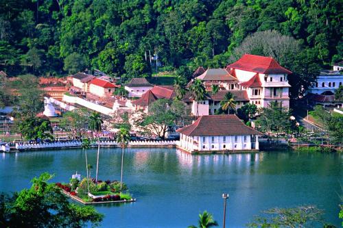 a small town on a lake with houses and trees at The Heaven's Villa Kandy in Kandy