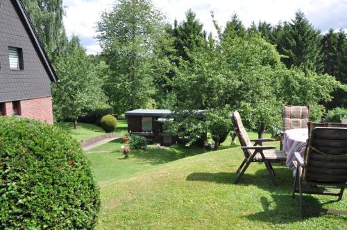 a garden with a table and chairs in the grass at Pension Dabrunz in Heimbach