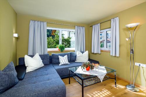 a living room with a blue couch and a table at Ferienraum Pfunds in Pfunds