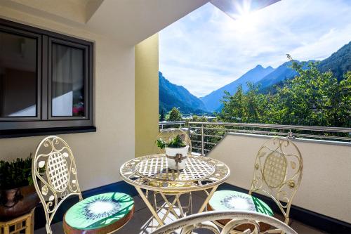 a table and chairs on a balcony with a view of mountains at Ferienraum Pfunds in Pfunds