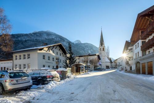 a snowy street in a town with a church at Ferienraum Pfunds in Pfunds