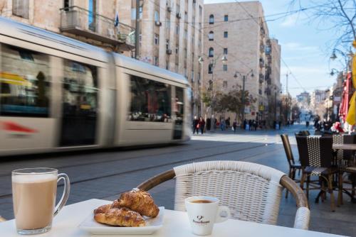 a table with a plate of food and a cup of coffee at Leonardo Boutique Jerusalem in Jerusalem