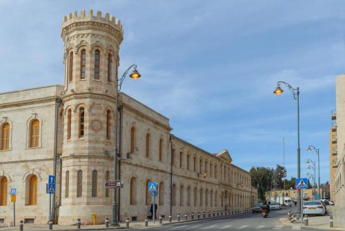 a building with a tower on the side of a street at Leonardo Boutique Jerusalem in Jerusalem