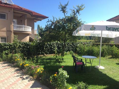 un patio con mesa y sombrilla en Apartments Villa Braho, en Pogradec