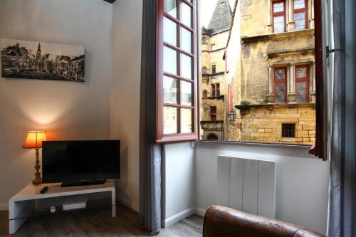 Il comprend un salon doté d'une télévision et d'une fenêtre. dans l'établissement L'Alcove, à Sarlat-la-Canéda