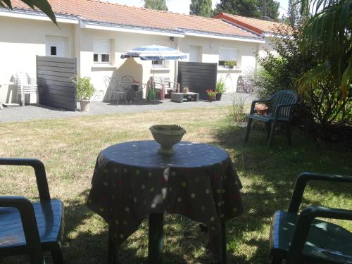 a table with a vase on it in a yard at Le Studio in Saint-Aignan-Grand-Lieu