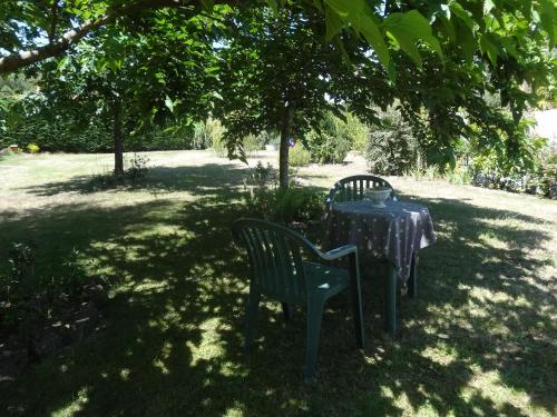 una mesa y dos sillas sentadas bajo un árbol en Le Studio, en Saint-Aignan-Grand-Lieu