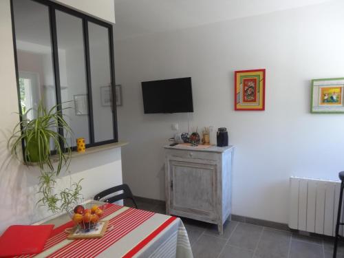 a dining room with a table and a television at Le Studio in Saint-Aignan-Grand-Lieu