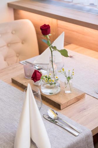 a table with a vase with a rose in it at Hotel Diana in Seefeld in Tirol
