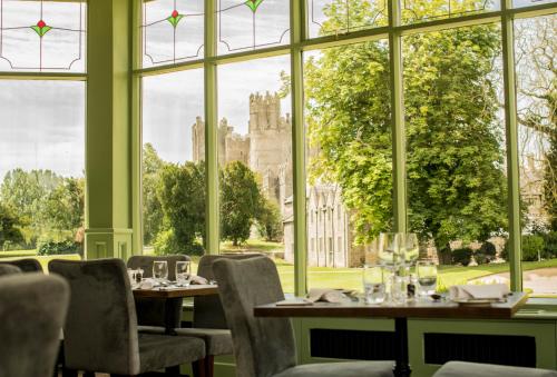 a restaurant with tables and chairs and a large window at The Lodges at Kilkea Castle in Kilkea