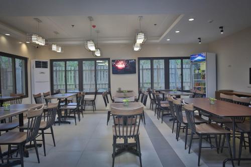 a dining room with tables and chairs and windows at Coron Soleil Express Hotel in Coron