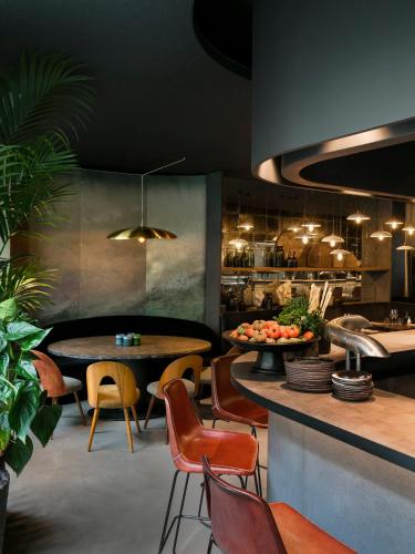 a restaurant with tables and chairs and a counter at Hôtel National Des Arts et Métiers in Paris