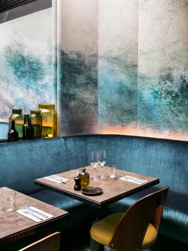a table in a restaurant with two tables and chairs at Hôtel National Des Arts et Métiers in Paris
