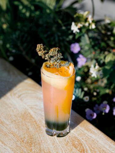 a drink sitting on a table with an orange at Hôtel National Des Arts et Métiers in Paris