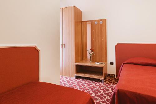ヴェノーザにあるHotel Villa Del Sorrisoのベッド2台と鏡が備わるホテルルームです。