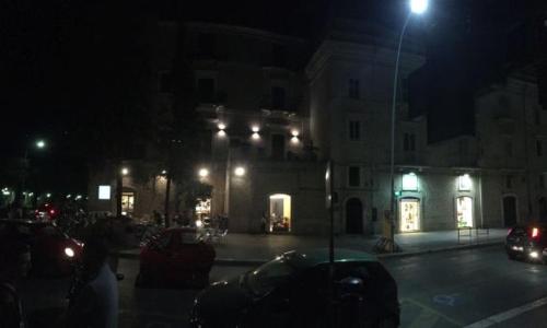 a street at night with cars parked in front of a building at Palace B&B in Acquaviva delle Fonti