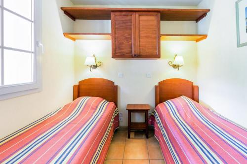 ウアール・シーズにあるResidence Le Parc d'Arradoy - maeva Homeのベッド2台が隣同士に設置された部屋です。
