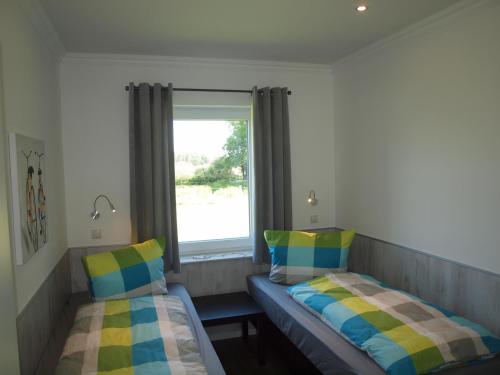 sypialnia z 2 łóżkami i oknem w obiekcie Kleine Brise w mieście Oberlangen