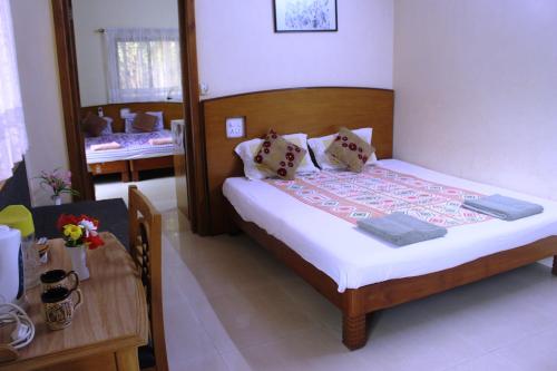 a small bedroom with a bed and a table at Mama Mids Home in Morjim