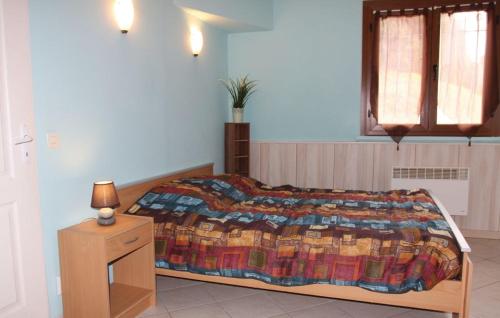 ein Schlafzimmer mit einem Bett mit einer bunten Decke darauf in der Unterkunft La fontaine in Aiguèze