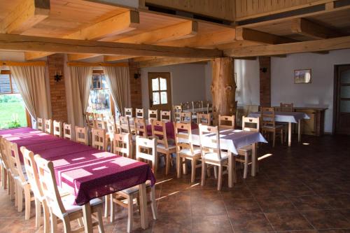 a dining room with tables and chairs in a building at Pensiunea Gerendás Vendégház in Vlăhiţa